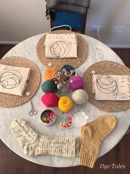 Mesa del taller de tejido de Dye Tales con lanas y calcetines